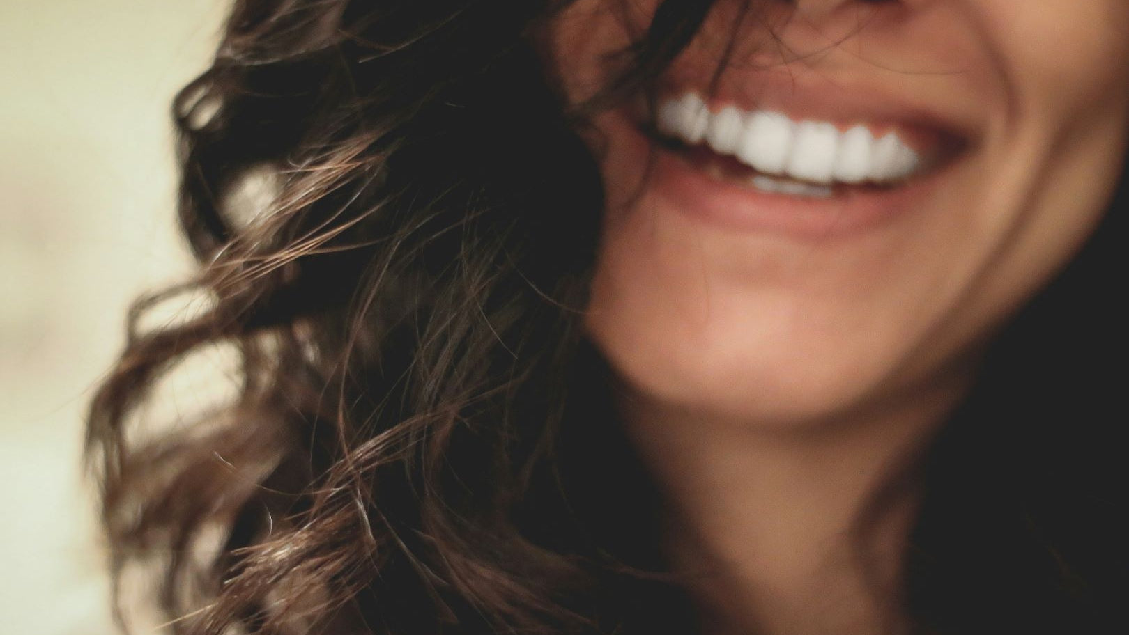 Close-up of a woman smiling with wavy hair